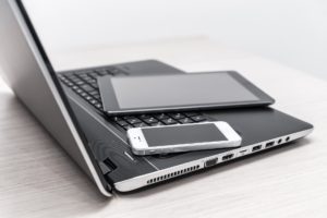 Laptop, phone, and tablet to illustrate the flexibility of using a VoIP phone system in business