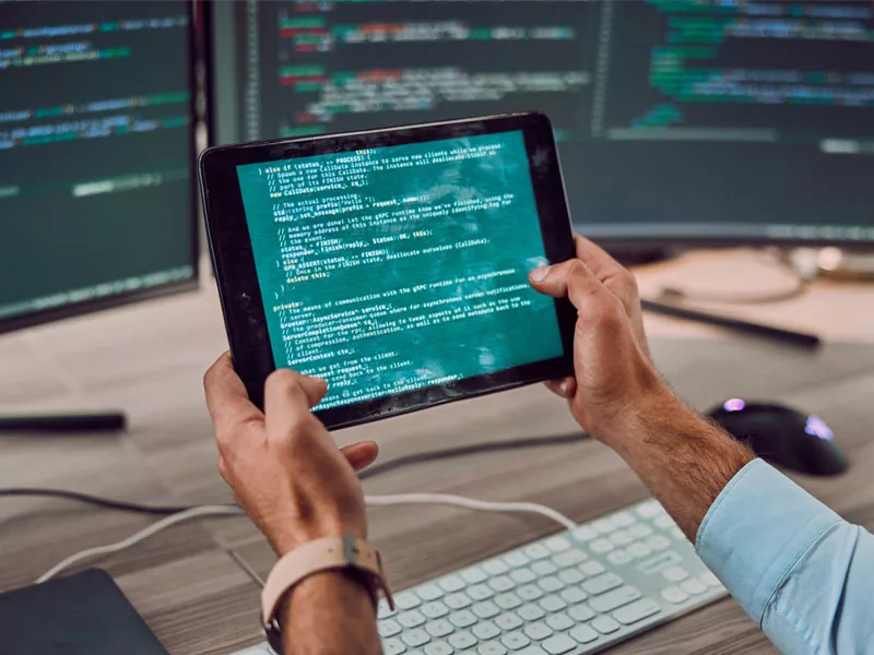 man with coding on his computer screen to illustrate IT outsourcing