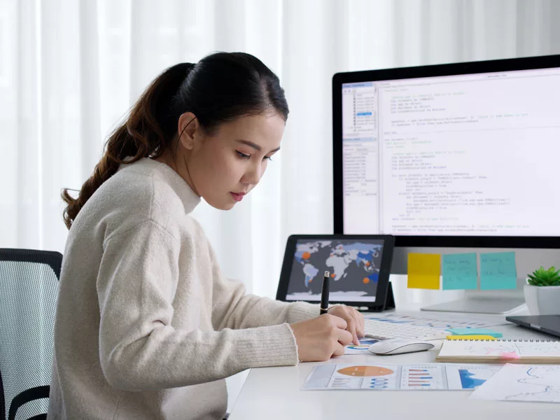 Young Asian business woman working at her home office desk, to illustrate cybersecurity for small businesses
