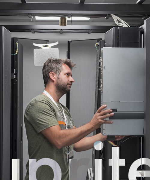 IT engineer working In the server room or data center. The technician puts in a rack a new server of corporate business mainframe supercomputer or cryptocurrency mining farm.